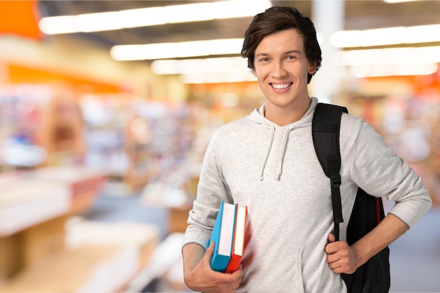 Studente maschio con zaino sullo sfondo