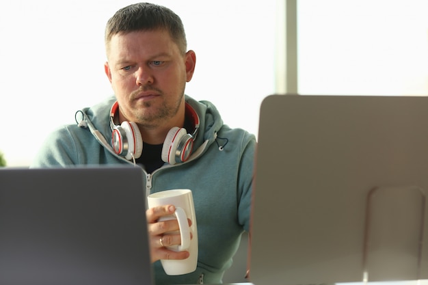 Studente maschio sorridente bello che usando online