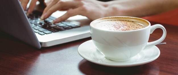 Studente maturo che utilizza computer portatile nel caffè