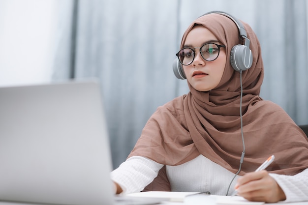 Studente musulmano che utilizza un laptop per l'apprendimento a distanza