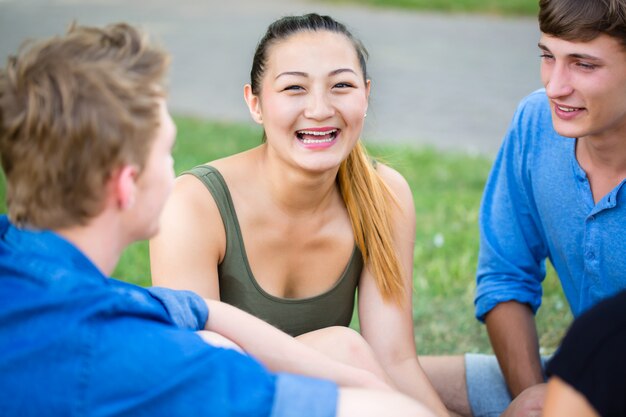 Studente nel parco parlando avendo picnic al fiume