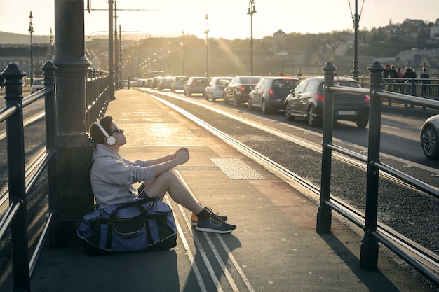 Studente ragazzo in una fermata del tram in città