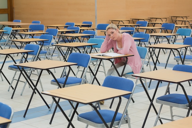 Studente seduto alla scrivania nella sala esame vuota