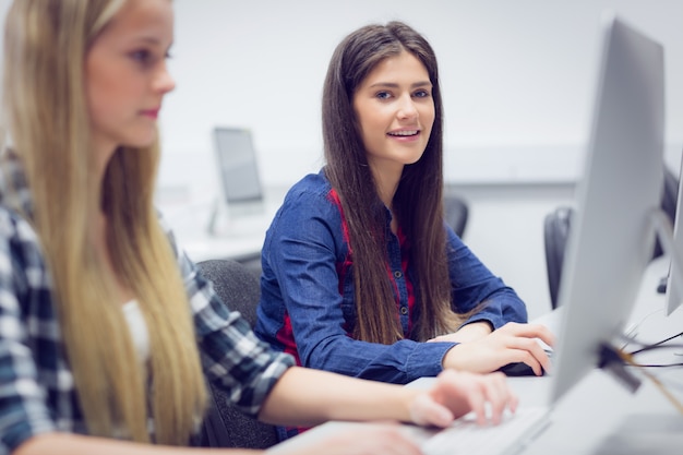 Studente sorridente che lavora al computer all&#39;università