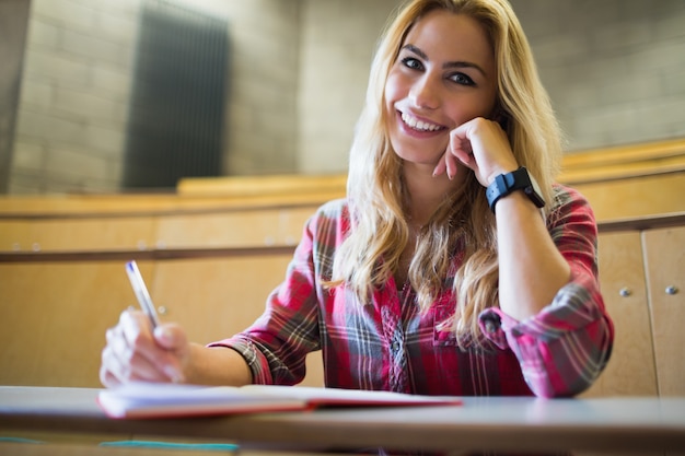 Studente sorridente che posa per la macchina fotografica nel corridoio di conferenza