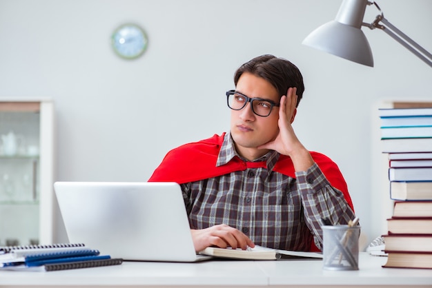 Studente supereroe con libri che studiano per gli esami