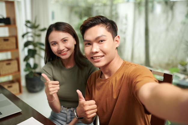 Studente universitario adolescente sorridente che si fa un selfie con la ragazza.