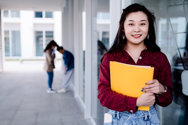 Studente universitario femminile che tiene le cartelle