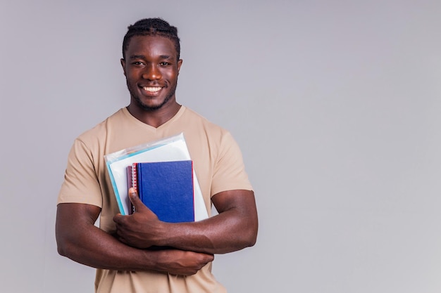 Studente uomo afroamericano con zaino in studio che sorride alla telecamera con un sorriso bianco