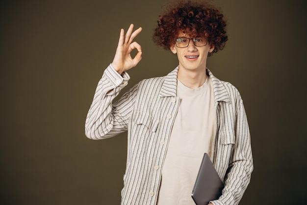 Studente uomo isolato in studio con laptop