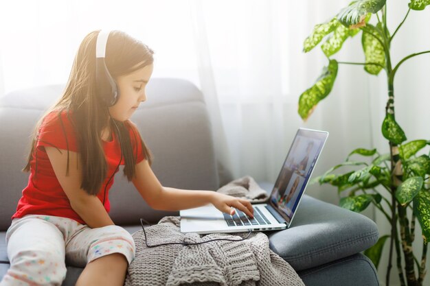 Studentessa abbastanza elegante che studia i compiti di matematica durante la sua lezione online a casa, distanza sociale durante la quarantena, autoisolamento, concetto di educazione online, scolaro a casa