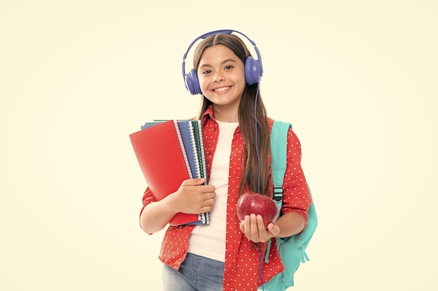 Studentessa adolescente in cuffie e libri su sfondo studio isolato Bambini della scuola