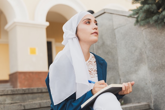 Studentessa araba seduta sulle scale nel centro cittadino