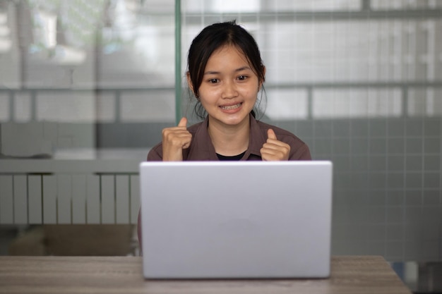 Studentessa asiatica che lavora su un computer portatile durante il giorno