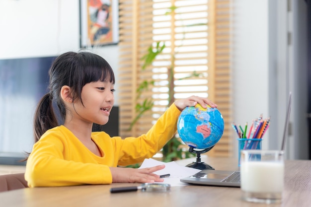 Studentessa asiatica classe di apprendimento online studio videochiamata online insegnante zoom, ragazza felice impara la lingua inglese online con il laptop a casa.Nuova normalità.Covid-19 coronavirus.Distanziamento sociale.rimani a casa