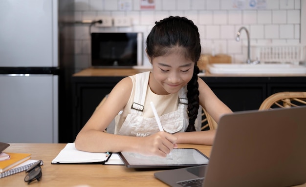 Studentessa asiatica classe di apprendimento online studio videochiamata online insegnante zoom Ragazza felice impara la lingua inglese online con il laptop a casaNuova normalitàCovid19 coronavirusDistanziamento socialestai a casa