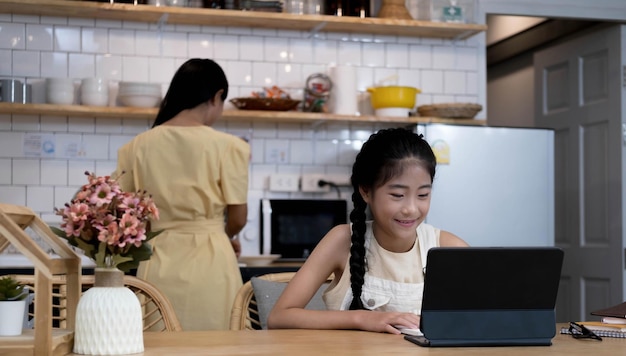 Studentessa asiatica di scuola domestica che impara la lezione online di Internet virtuale dall'insegnante di scuola tramite una riunione remota a causa della pandemia di covid Femmina che insegna matematica usando le cuffie e la lavagna