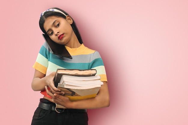 Studentessa asiatica indiana seria carina in posa isolata tenendo i quaderni e parlando su tablet Mock up spazio di copia