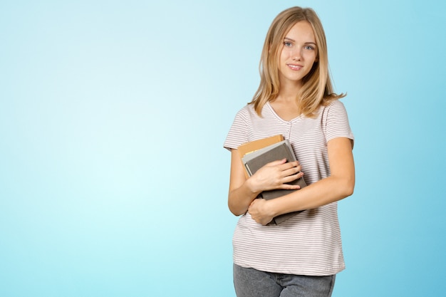 Studentessa bionda con una pila di libri