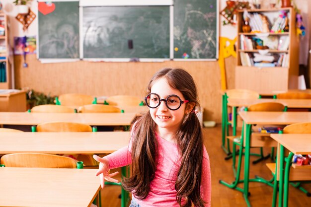 Studentessa carina con grandi occhiali divertenti, sta parlando