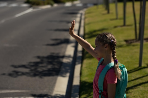 Studentessa caucasica che saluta un passaggio pedonale