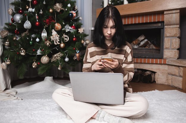 Studentessa che ascolta lezione educativa sul computer guardando il webinar che studia sui corsi online scrivendo note nel concetto di elearning del quaderno cartaceo