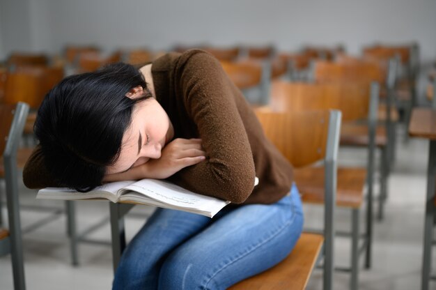 Studentessa che dorme in un'aula universitaria