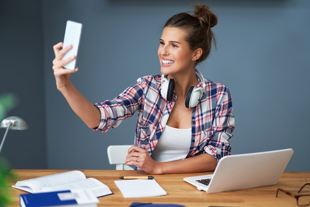 Studentessa che impara a casa e si fa selfie