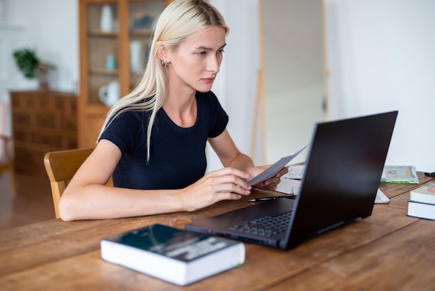 Studentessa che lavora o studia utilizzando il computer portatile a casa