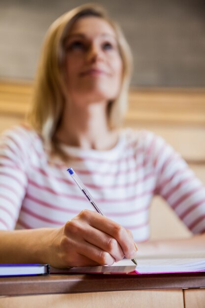 Studentessa che prende appunti in una classe all&#39;università