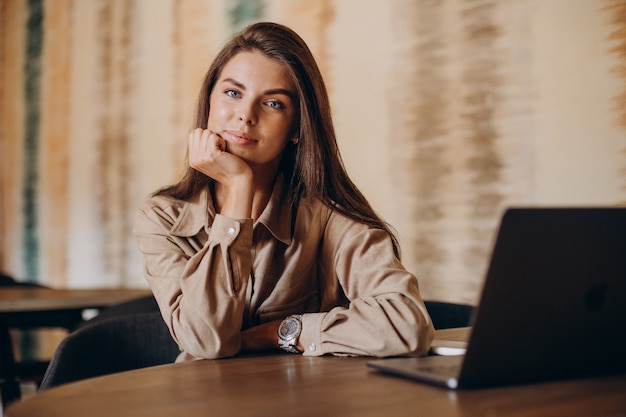 Studentessa che studia sul computer portatile in un caffè