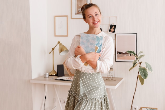 Studentessa con i taccuini nelle sue mani a casa