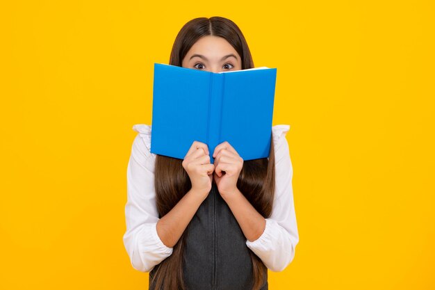 Studentessa con libro di copia in posa su sfondo isolato Lezione di letteratura scuola di grammatica Lettore intellettuale del bambino