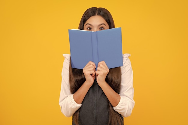 Studentessa con libro di copia in posa su sfondo isolato Lezione di letteratura scuola di grammatica Lettore intellettuale del bambino