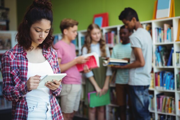 Studentessa con tavoletta digitale in libreria