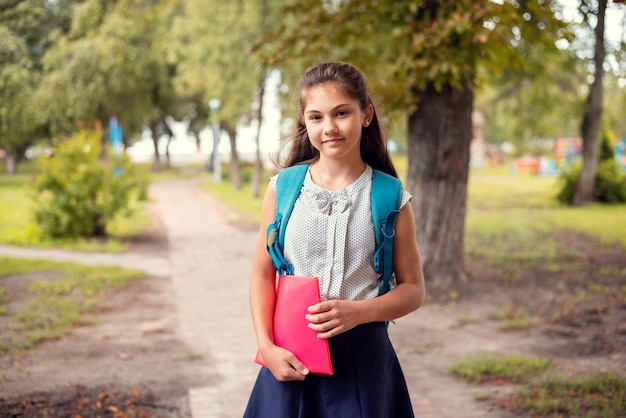 Studentessa della scuola secondaria che va a scuola nel parco