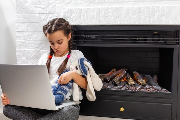 Studentessa di una bambina che studia lezione online con un laptop a casa, nuova normalità. covid-19-coronavirus. Distanziamento sociale, scuola a casa.