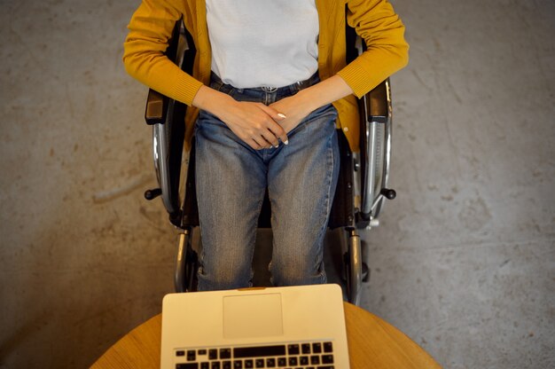 Studentessa disabile in sedia a rotelle che utilizza laptop