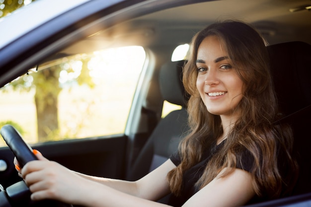 Studentessa felice guida auto subito dopo aver ricevuto la patente auto