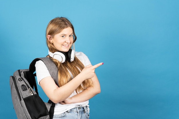 Studentessa graziosa che indica lo spazio blu della copia