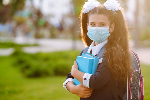 Studentessa in maschera medica protettiva al tramonto. Quarantena per il covid19.