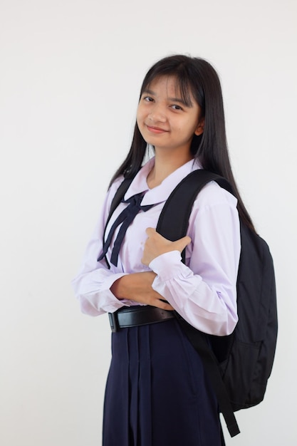 Studentessa in uniforme e zaino su sfondo bianco