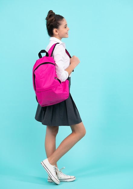 Studentessa in uniforme scolastica con borsa di scuola Studentessa adolescente su sfondo blu isolato Adolescente felice emozioni positive e sorridenti della ragazza adolescente
