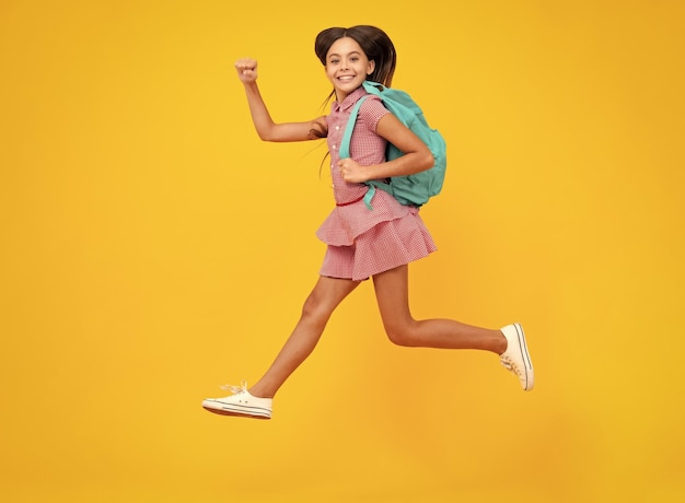 Studentessa in uniforme scolastica con zaino Studentessa adolescente su sfondo giallo isolato Scuola