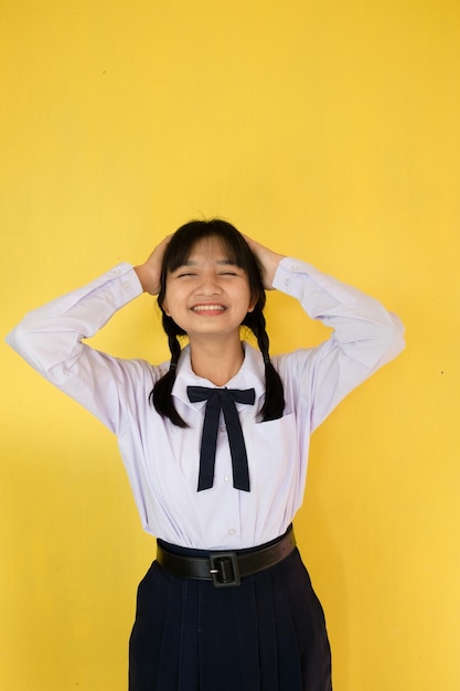 Studentessa in uniforme su sfondo giallo