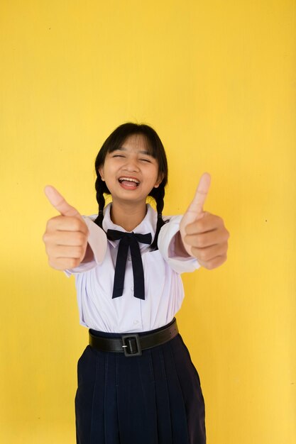 Studentessa in uniforme su sfondo giallo