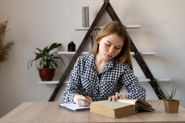 Studentessa online in una lezione con un tutor remoto prende appunti e studia senza guardare la telecamera Milenial è un libero professionista su Internet