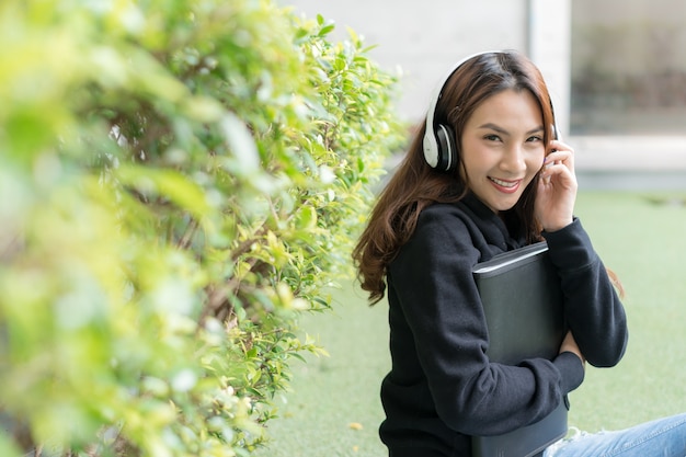 Studentessa seduta sul banco di prato al campus