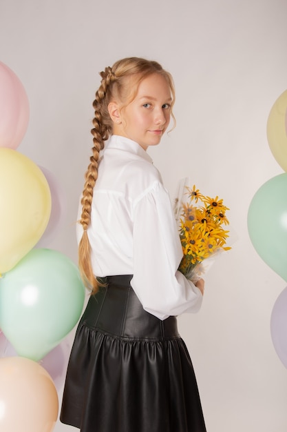 Studentessa, studentessa delle superiori con fiori e palline su sfondo bianco