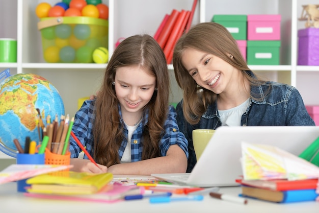 Studentesse carine in classe con laptop e tè